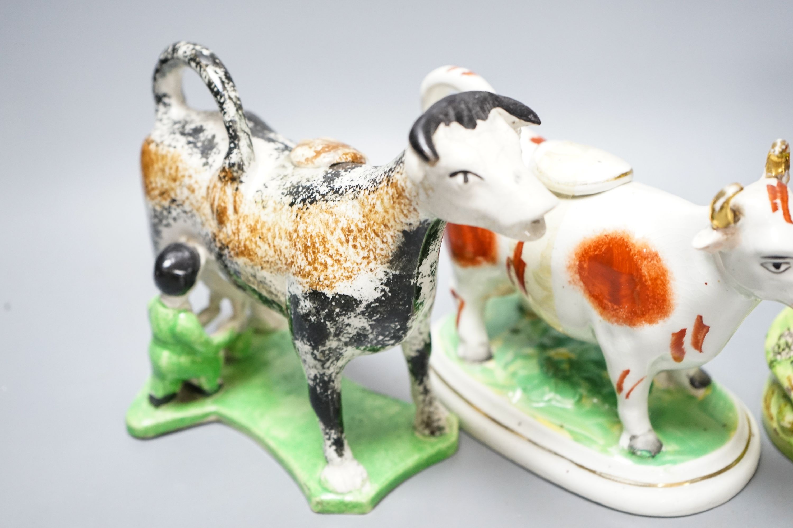 A 19th century 'Milkmaid and cow' creamer with sponged decoration, three other Staffordshire items and a Continental majolica figure of a turkey (5)